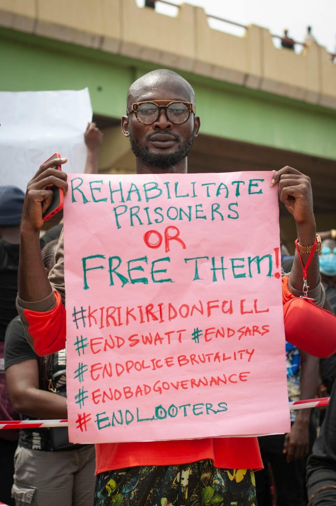A man holding a sign during a protest advocating for prisoner reform and social justice.
