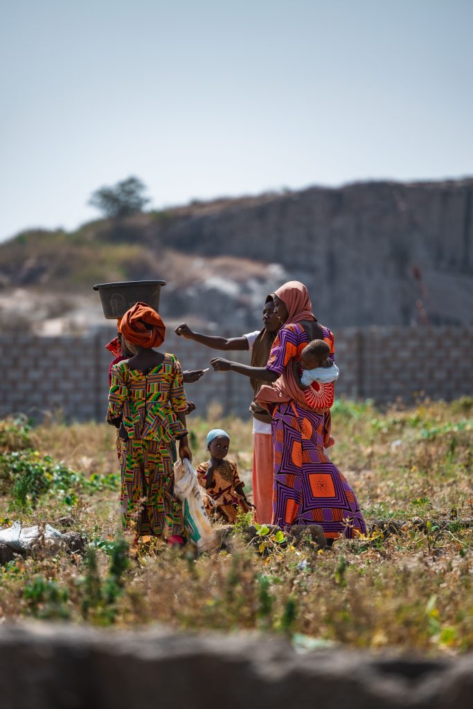 A group of women farming in Deidei, Nigeria, showcasing vibrant attire and rural life.