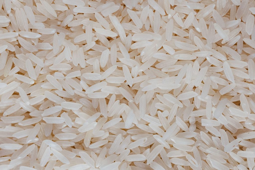 Detailed view of uncooked white rice grains, showcasing texture and pattern.