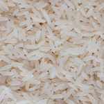 Detailed view of uncooked white rice grains, showcasing texture and pattern.