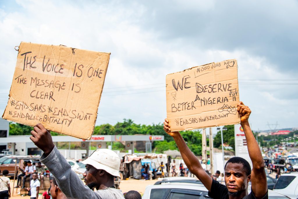 Demonstrators hold signs advocating for change during a protest in Nigeria.