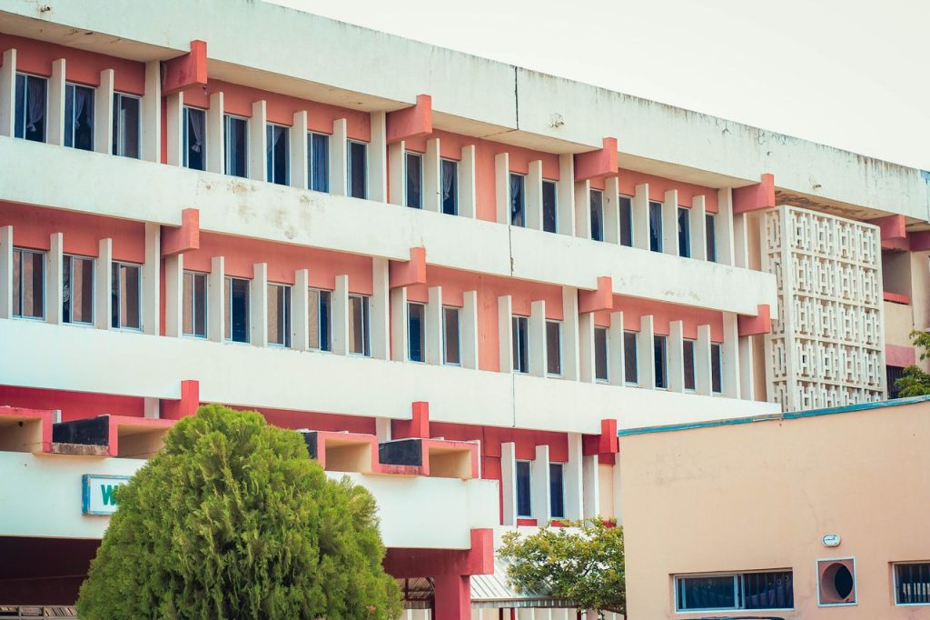 Modern multi-story building with red details captured in daylight.